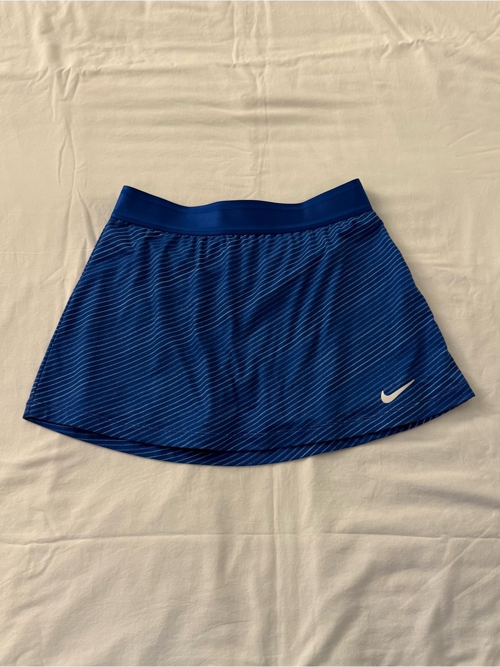 Nike blue tennis skirt with thin white diagonal stripes, size S